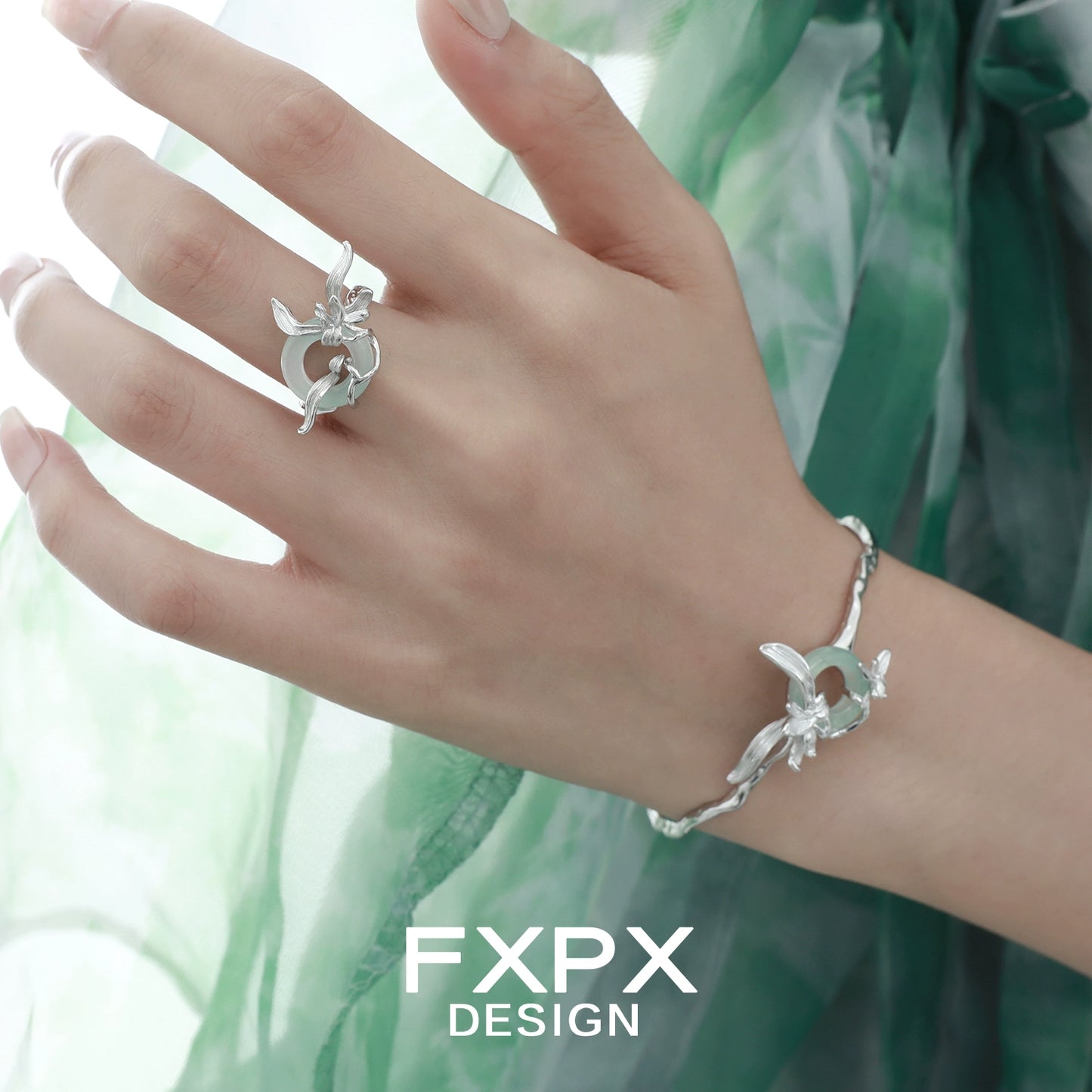 Silver iris flower bracelet by FXPX elegantly worn on a hand with a green background