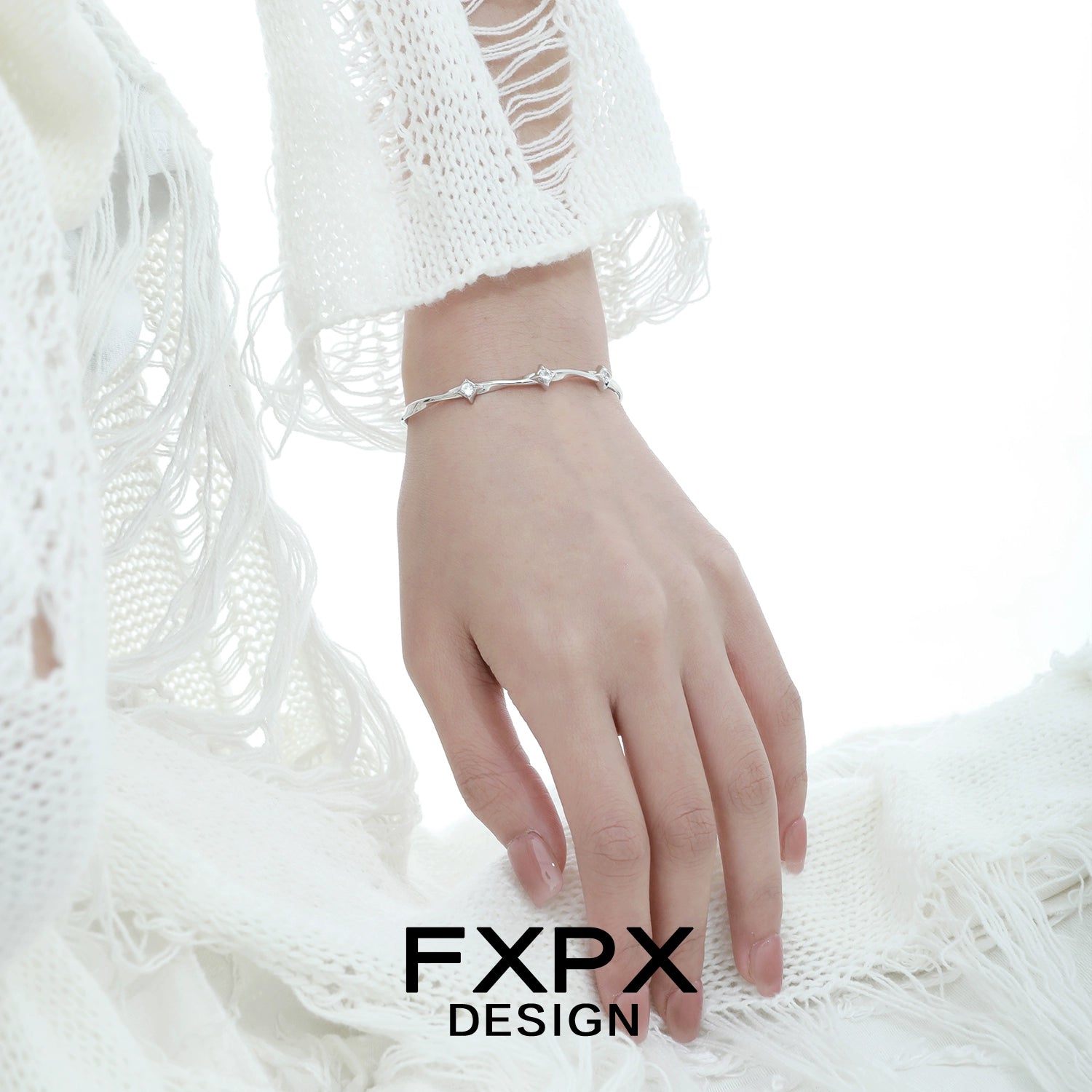 Elegant FXPX silver star bracelet displayed on a model's wrist, showcasing its delicate design