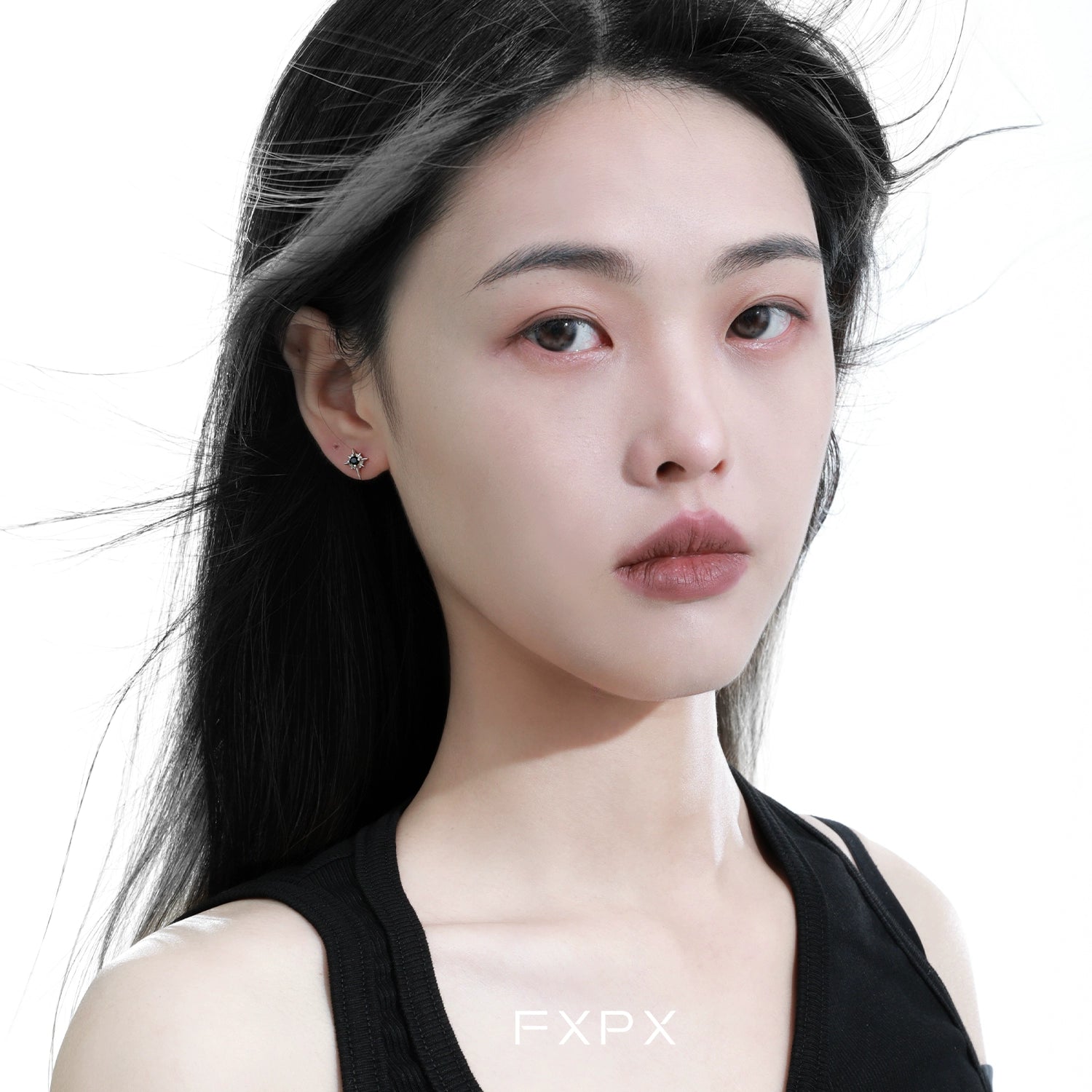Sleek FXPX star stud earrings showcased on a model with flowing hair for a stylish look