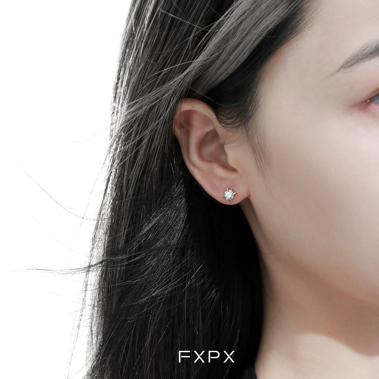 Elegant FXPX star stud earrings displayed on a model with long dark hair, showcasing their sparkling design