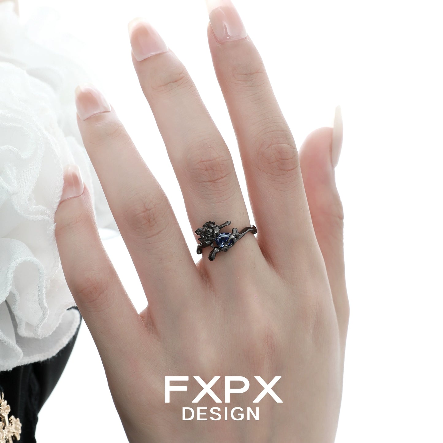 Elegant FXPX Tanzanian blue rose ring featuring a detailed floral design on a hand