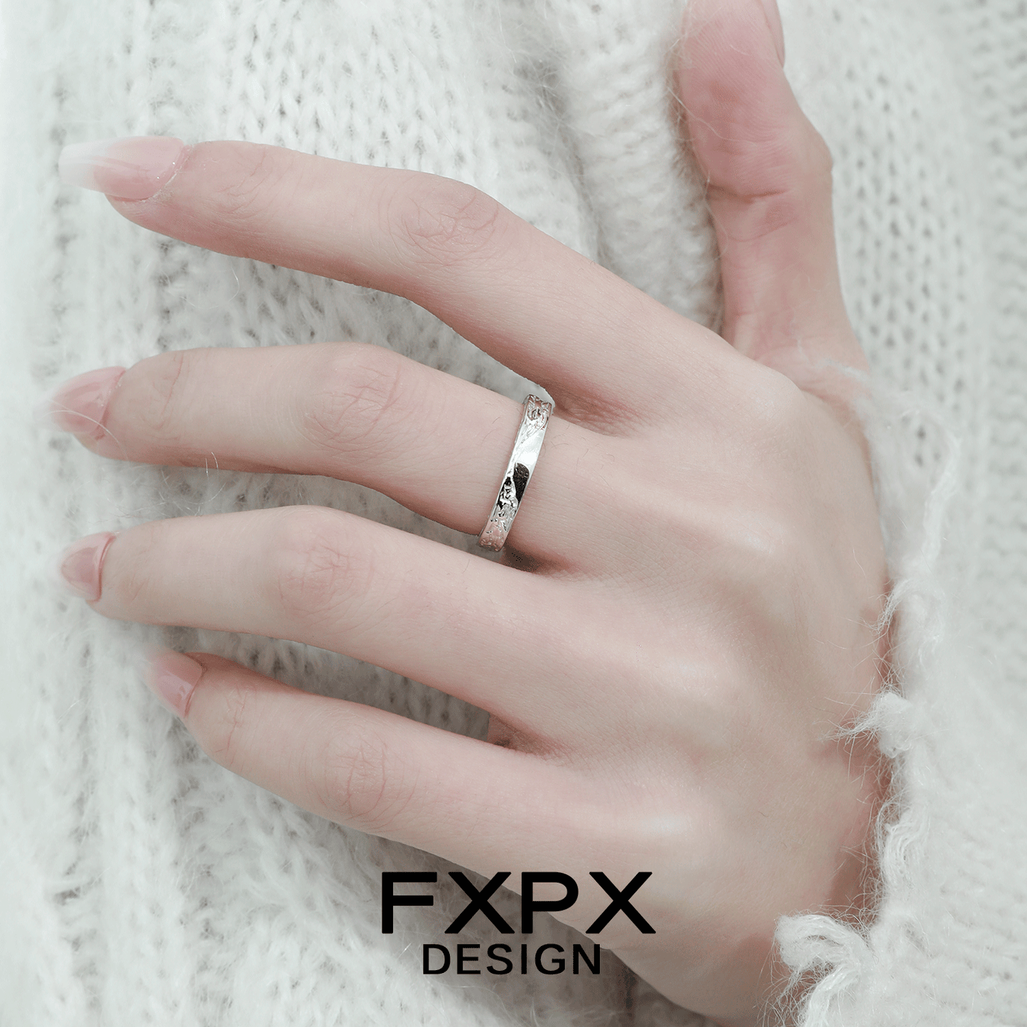 Stylish FXPX unique couple rings displayed on a hand with a cozy sweater background