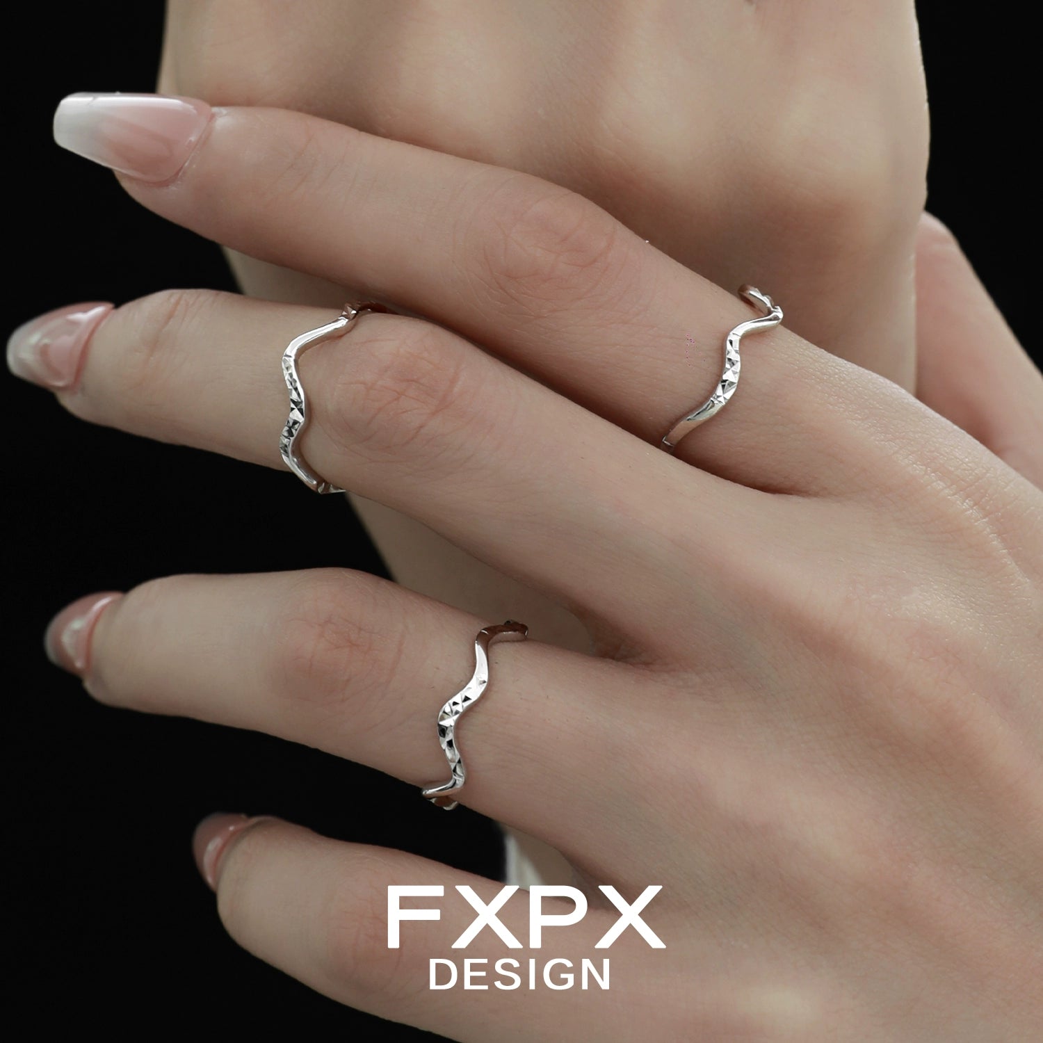 Stylish wavy silver ring showcased on elegant fingers with long nails