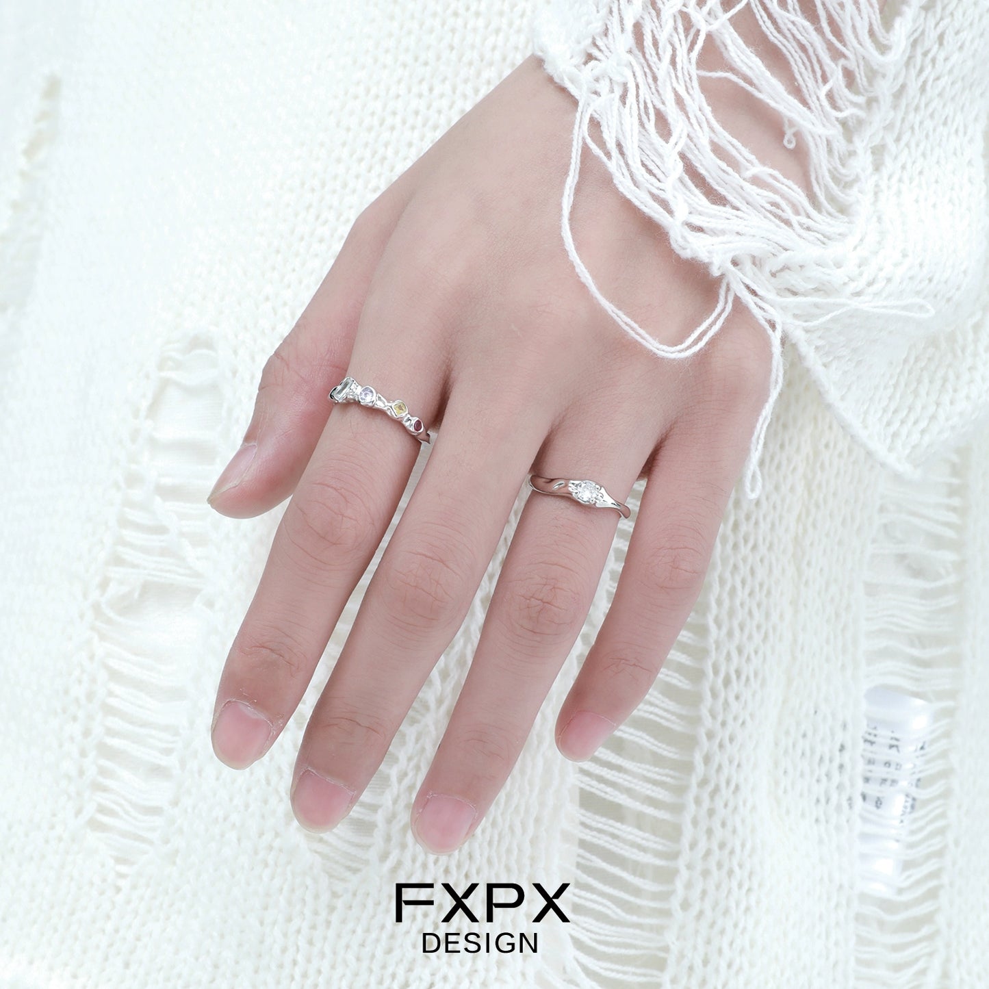 Stylish FXPX white zircon ring on a model's hand with a cozy sweater background