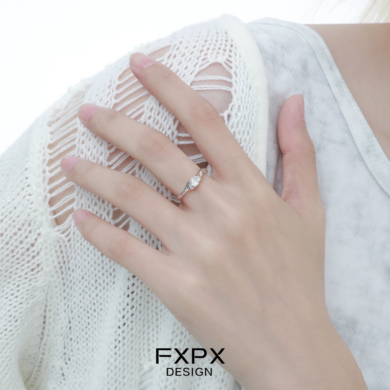 Elegant FXPX white zircon ring with a delicate twisted design on a model's hand