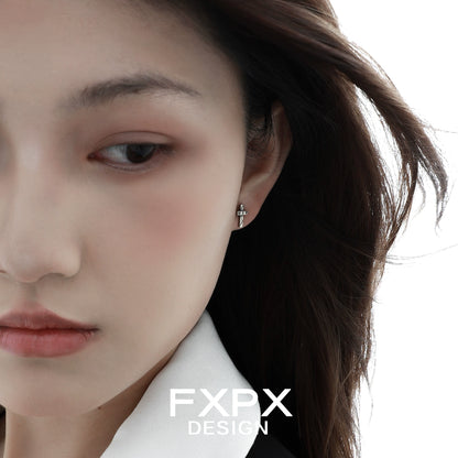 Close-up of Y2K punk cross earrings worn by a model with long hair and a stylish outfit
