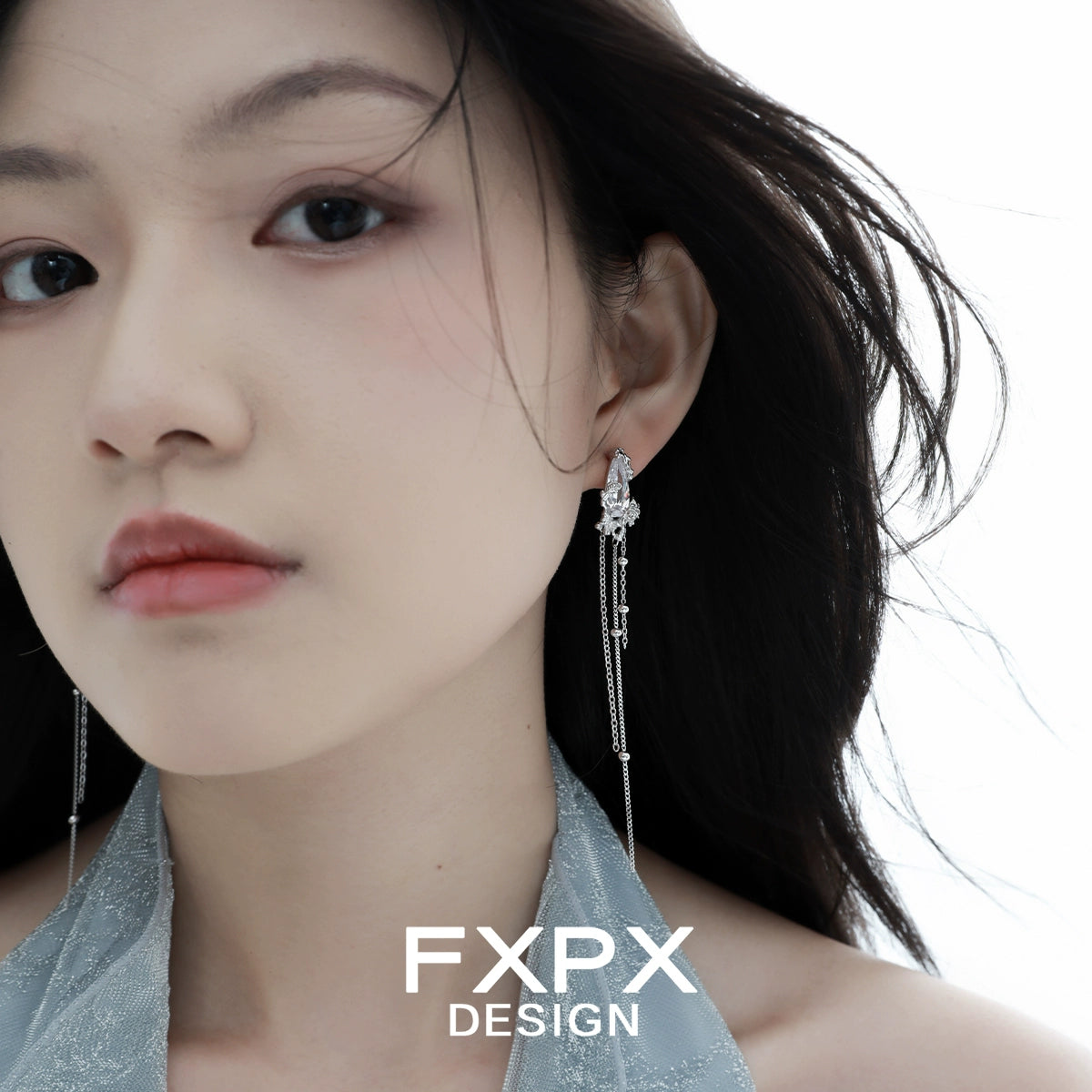 Y2K silver tassel earrings worn by a model with flowing hair and a soft expression