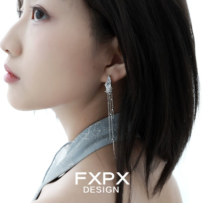Stylish FXPX Y2K silver tassel earrings worn elegantly by a model on a silky top