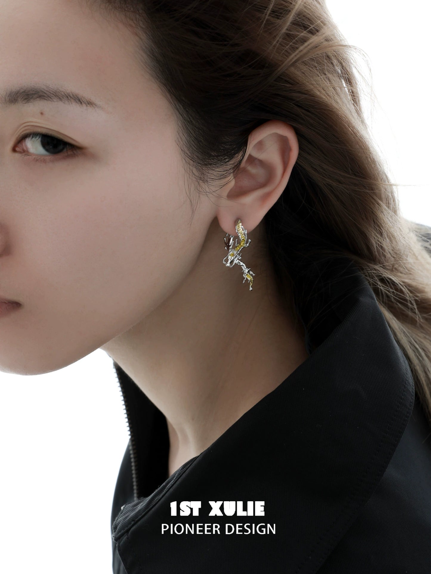 Gold dragon stud earrings in a stylish design worn by a model with flowing hair