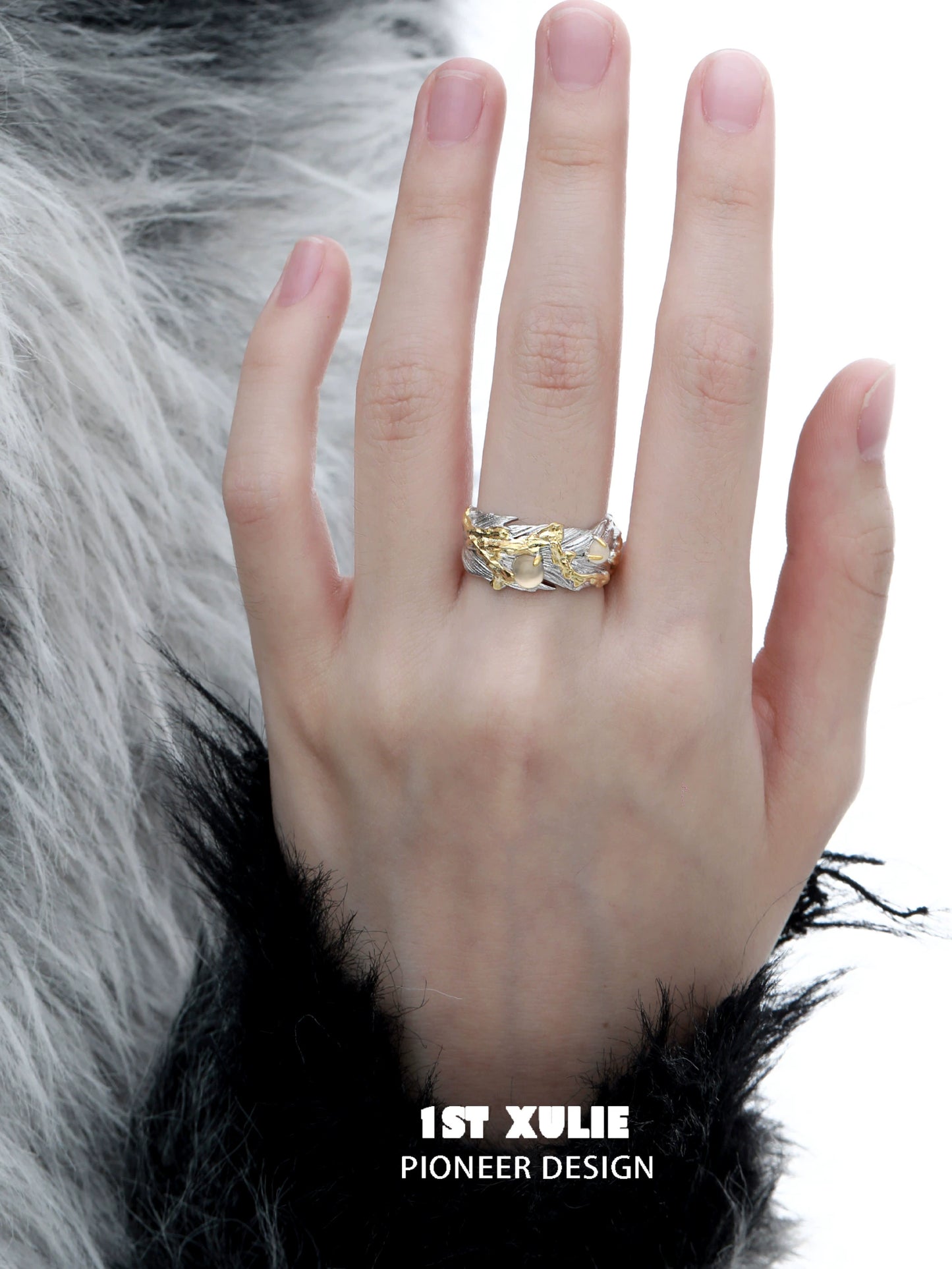 Gold feather ring on a hand with a textured background for elegant style