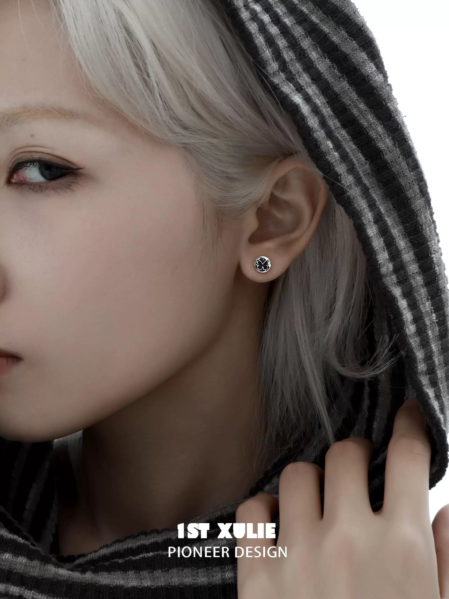 Gothic butterfly earrings displayed on a model wearing a hoodie with striking features