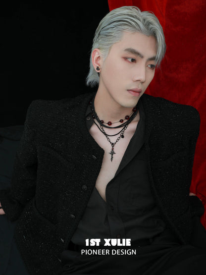Stylish man showcasing a gothic cross necklace layered with beads for a trendy look