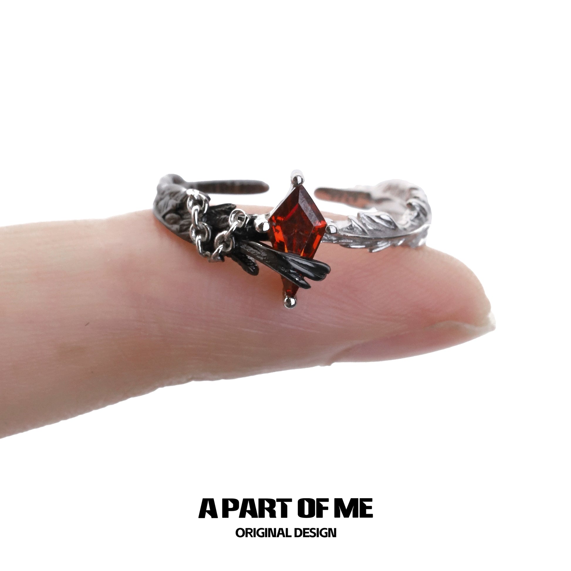 Gothic feather ring by A PART OF ME featuring a dark design with a red gemstone accent