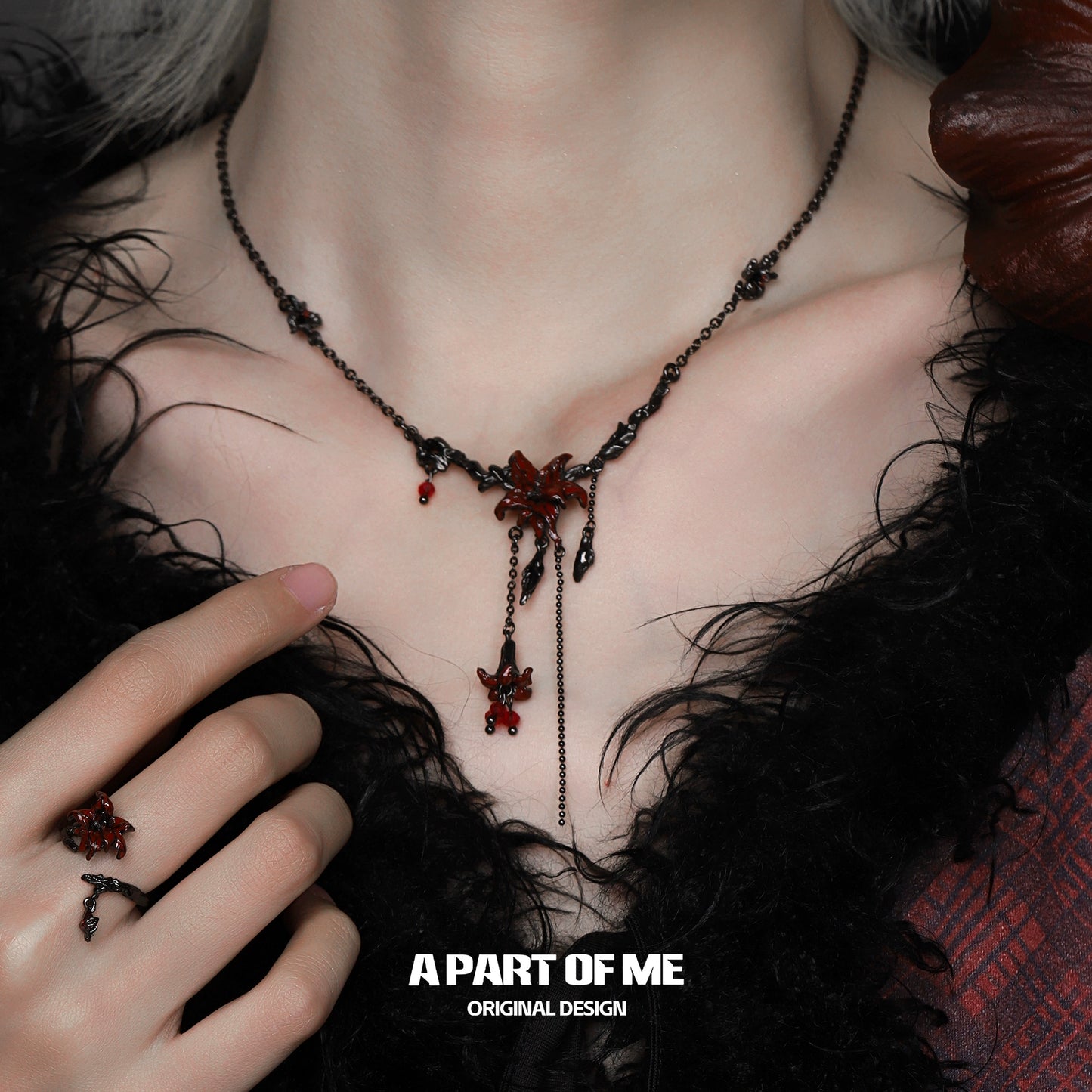 A gothic mandala necklace with intricate design and red accents, worn against a dark, textured background
