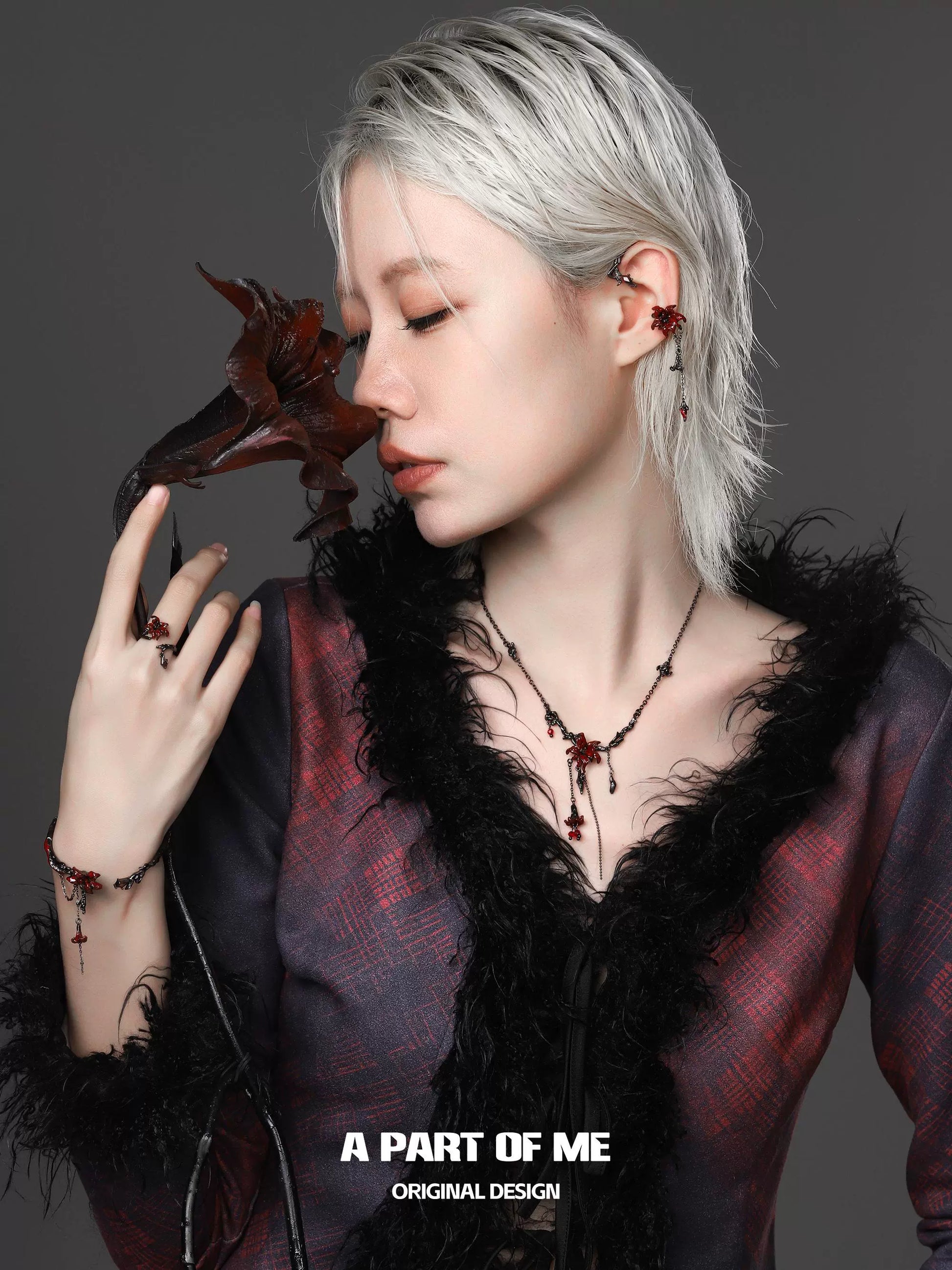 A woman wearing a gothic mandala ring along with matching jewelry in a stylish outfit