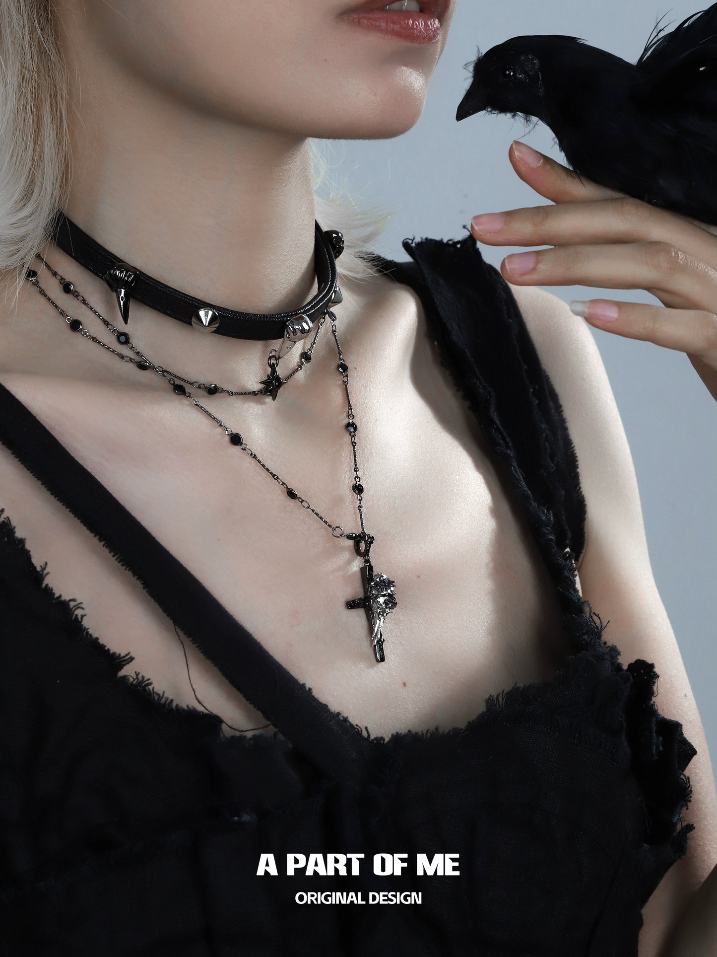 Stylish gothic raven cross necklace layered with black choker and silver details for a bold look