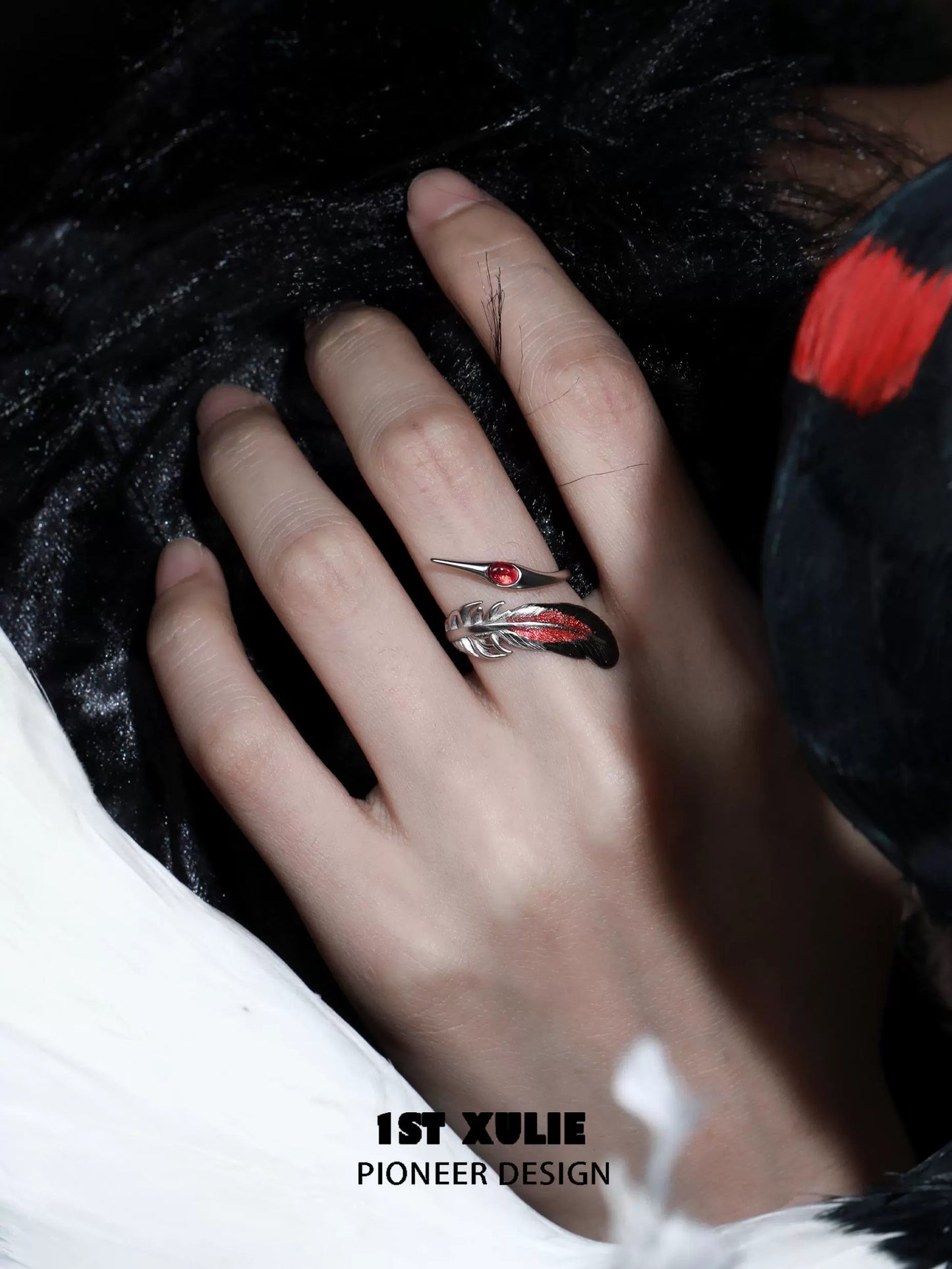 Gothic silver crane ring with intricate design and red gemstone, worn on a hand against a dark background