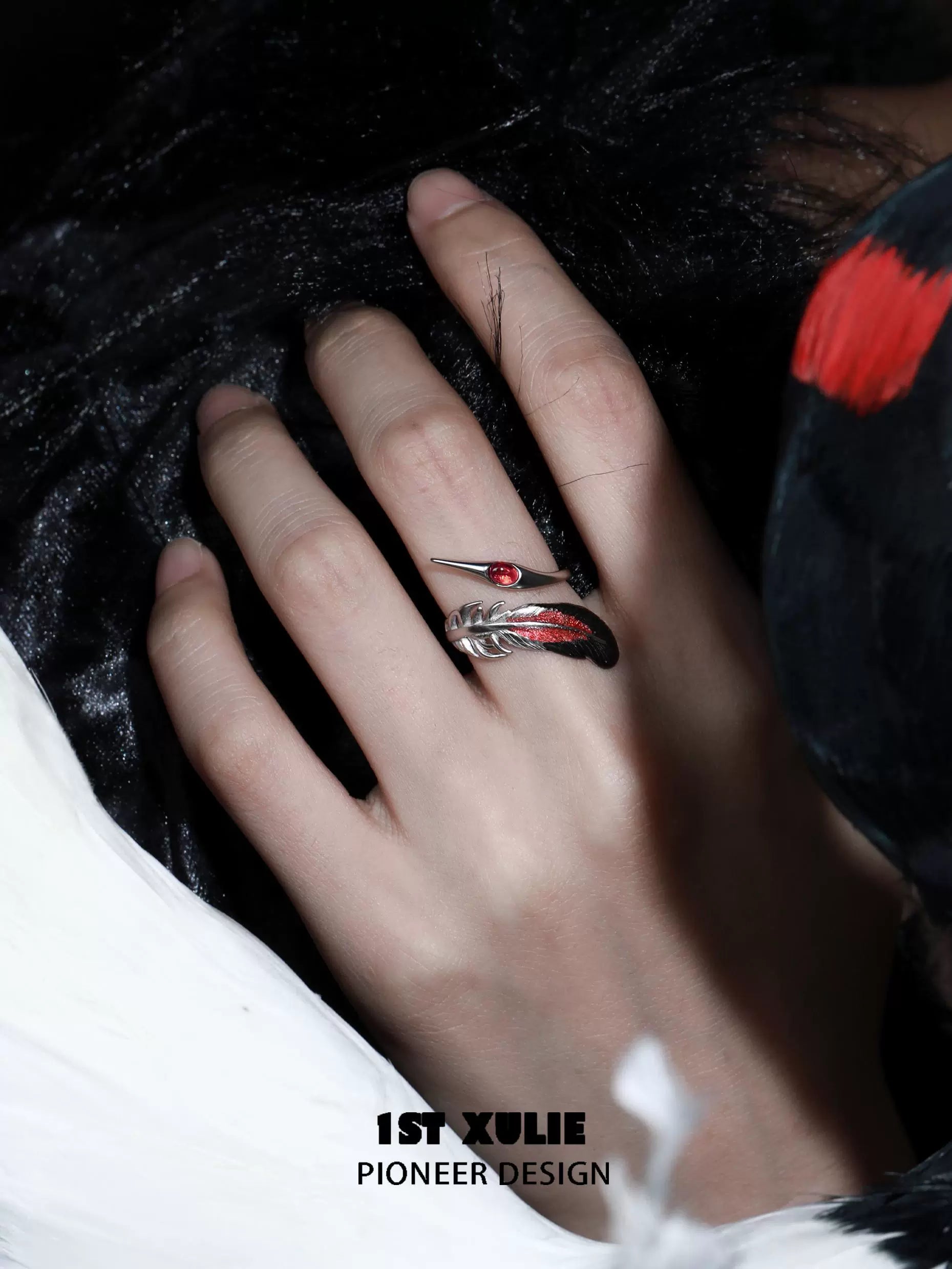 Gothic silver crane ring with intricate design and red gemstone, worn on a hand against a dark background