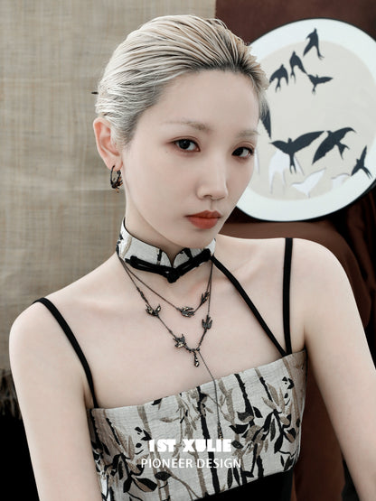 Model wearing gothic swallow earrings with intricate design, complemented by stylish outfit featuring floral patterns