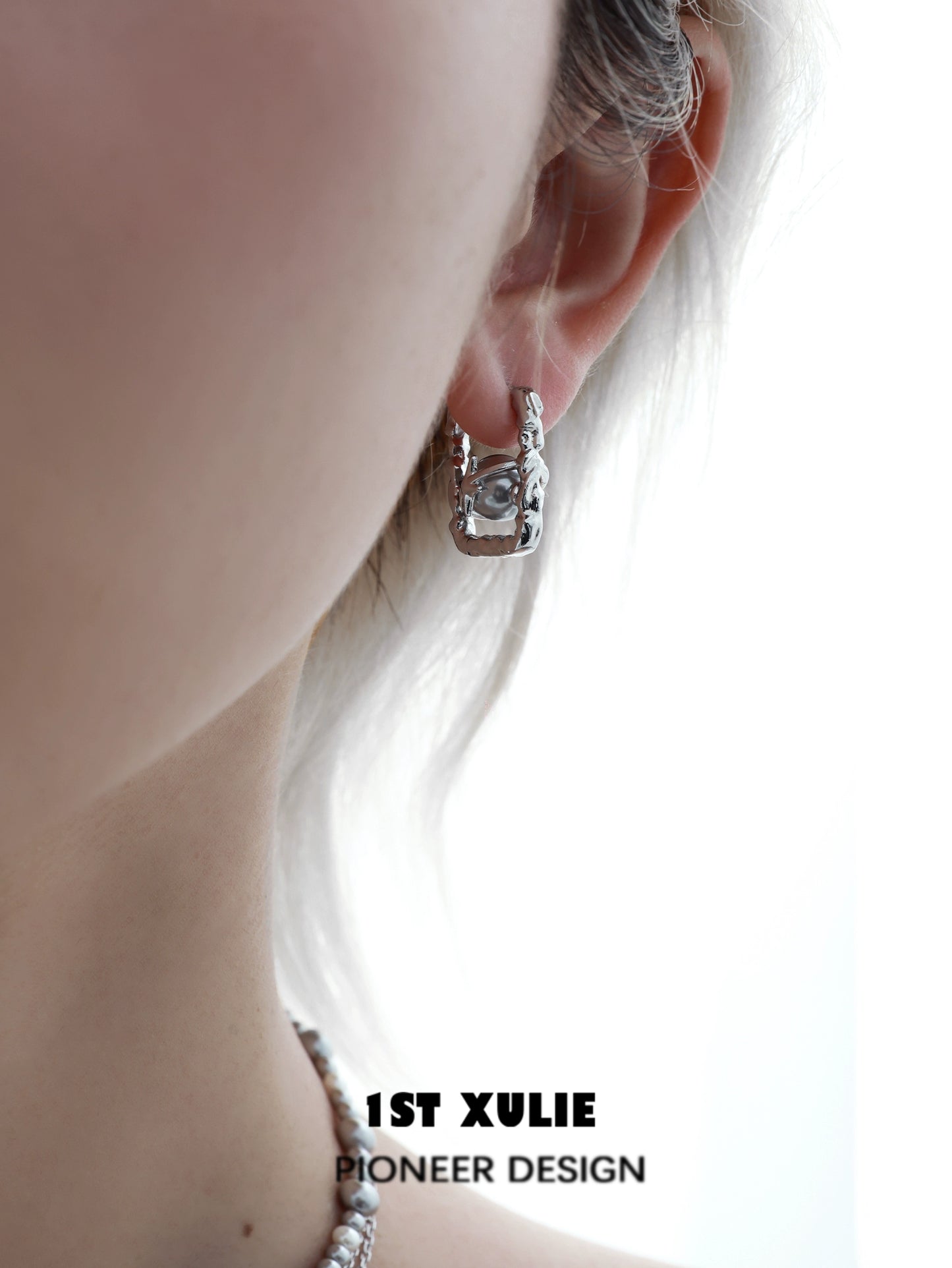 Stylish gray pearl star earrings displayed on a model's ear for a chic look