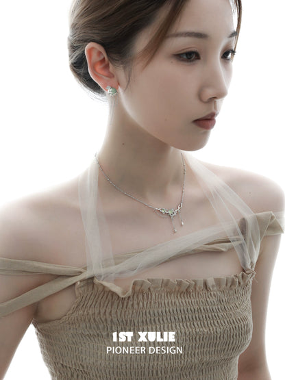 Elegant green gem silver necklace worn by a model, showcasing its unique design and sparkle