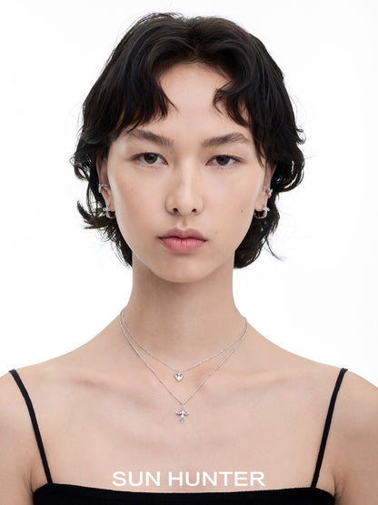 Model wearing SUN HUNTER heart cross double layer necklace with silver chain and delicate pendants