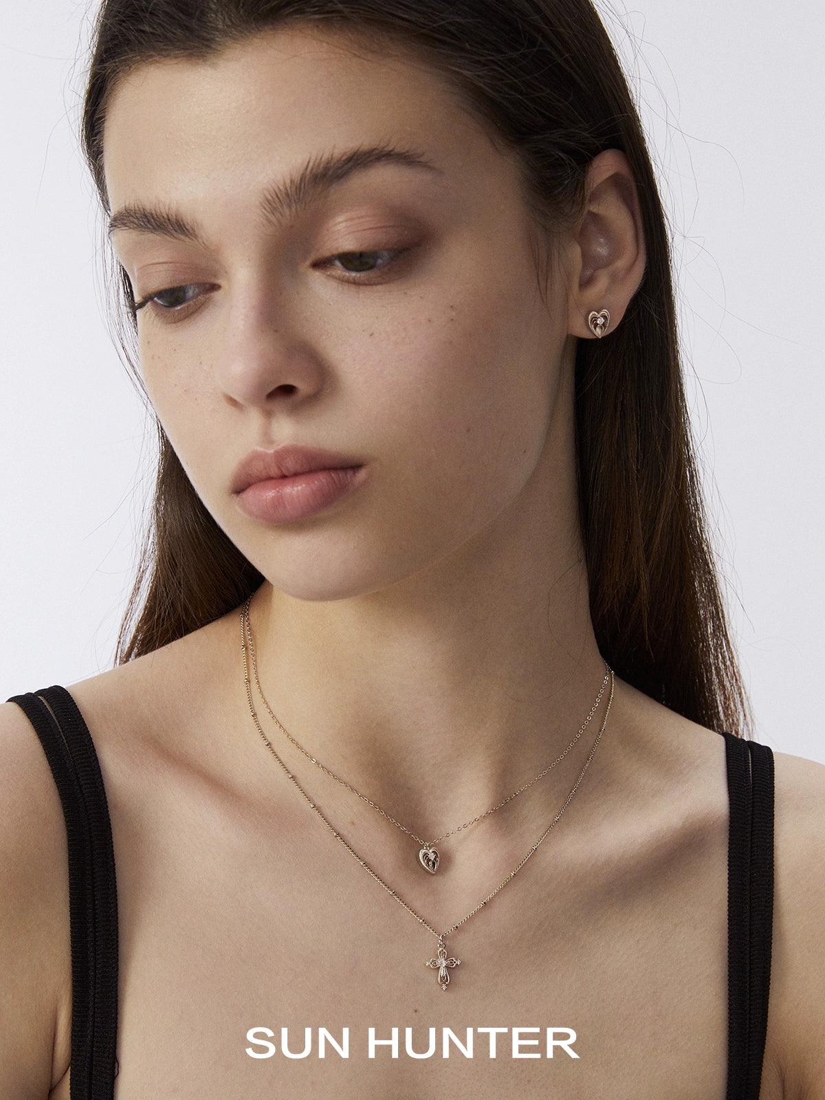 Elegant heart cross double layer necklace by SUN HUNTER worn by a model, showcasing its delicate design