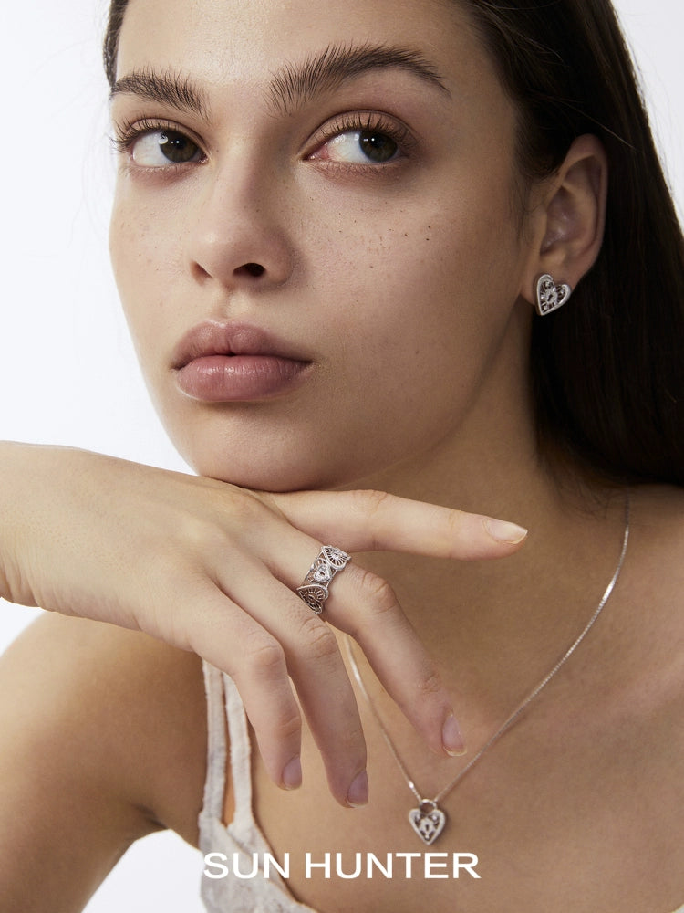 Elegant SUN HUNTER heart lock ring showcased on a model's hand with matching heart-shaped jewelry