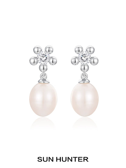 Elegant SUN HUNTER island flower pearl earrings with sparkling flower design and creamy pearl drop