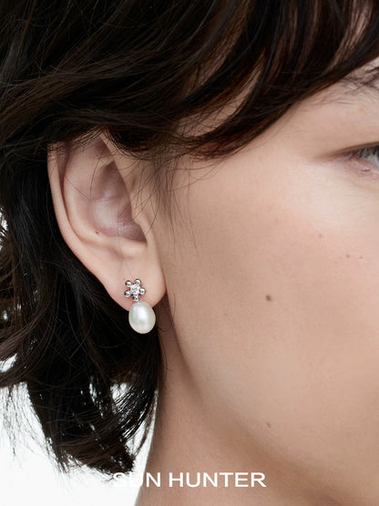 Elegant SUN HUNTER island flower pearl earrings featuring a delicate pearl drop design