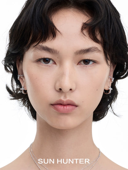 Model wearing SUN HUNTER lace cross earrings showcasing intricate design and stylish elegance
