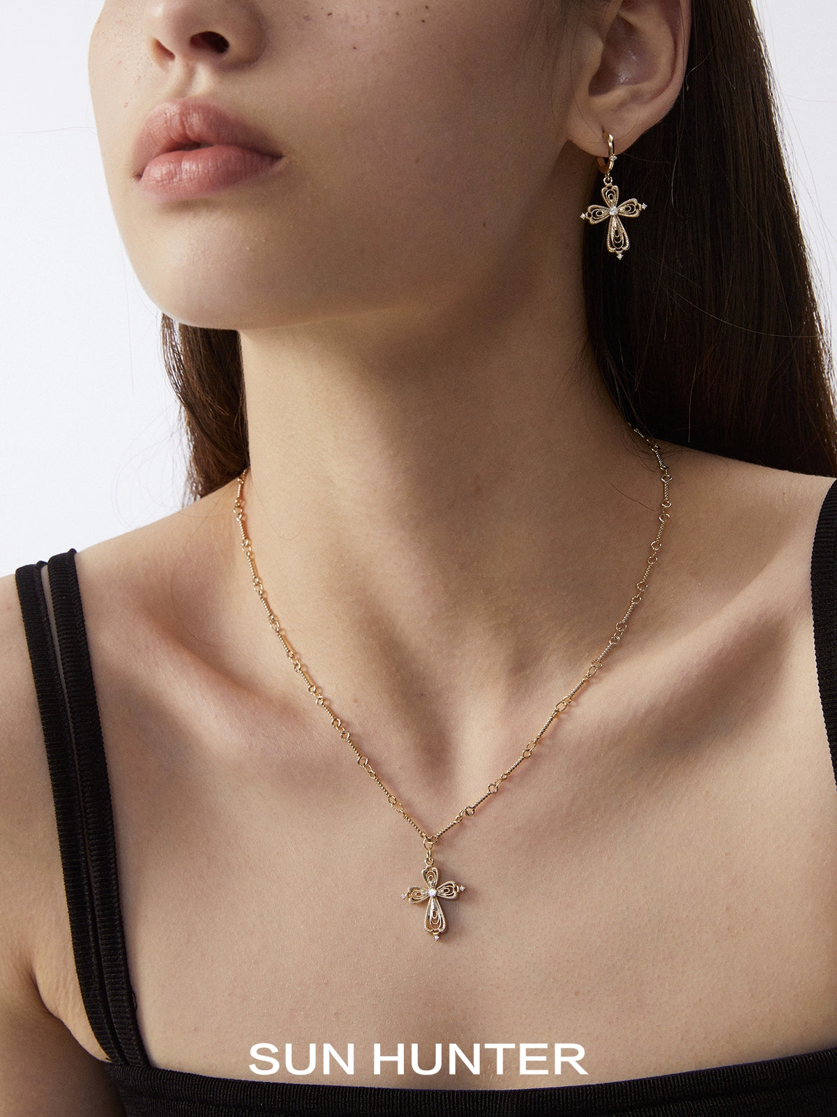 Elegant SUN HUNTER lace cross necklace featuring a delicate design and sparkling accents