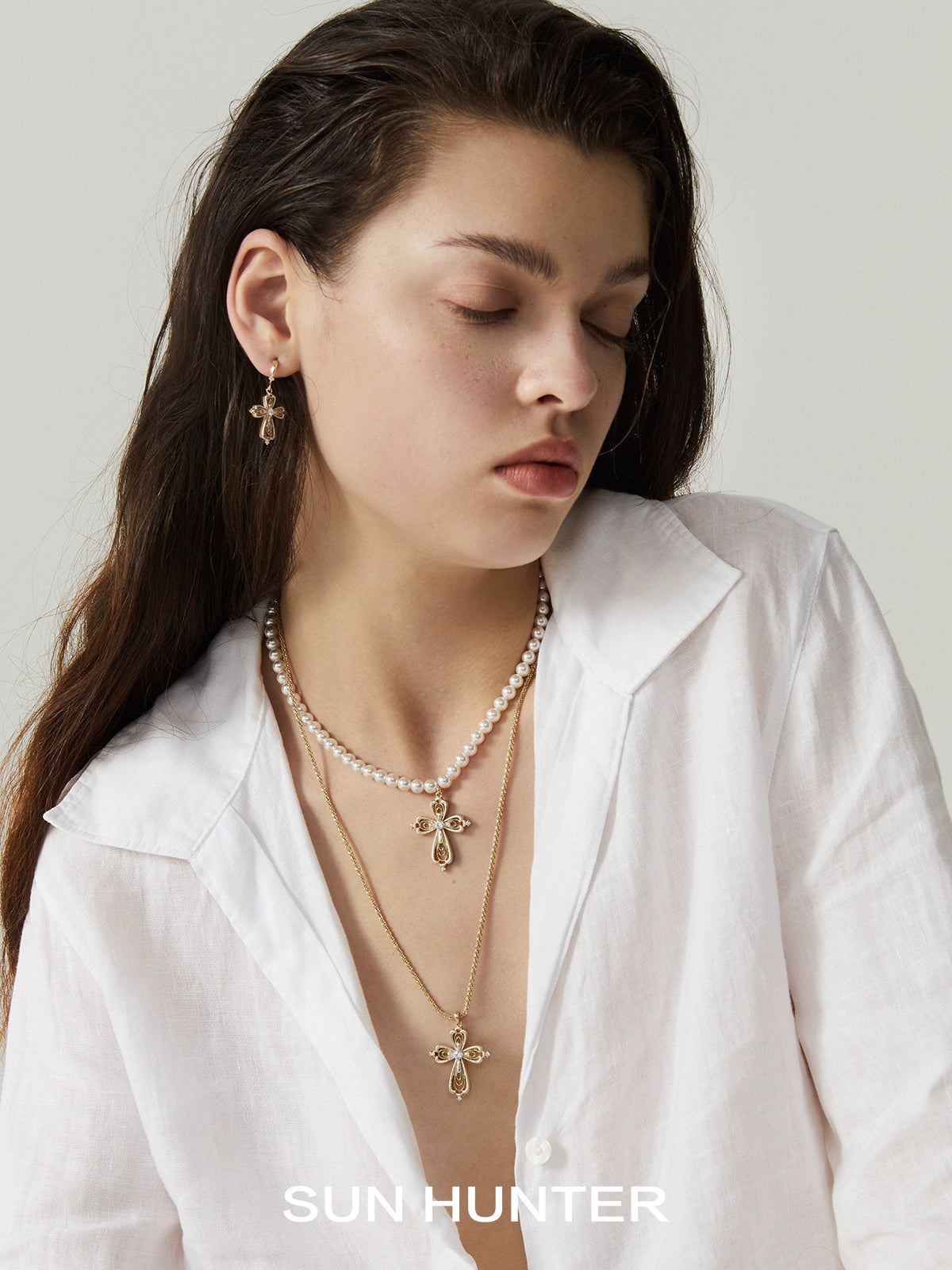Elegant lace cross necklace by SUN HUNTER paired with pearl accents for a chic look
