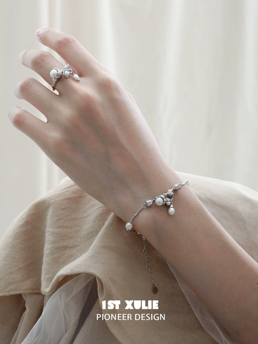 Elegant lily of the valley pearl bracelet on hand, showcasing delicate floral design and lustrous pearls