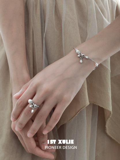 Elegant lily of the valley pearl bracelet on a model's wrist showcasing delicate floral design