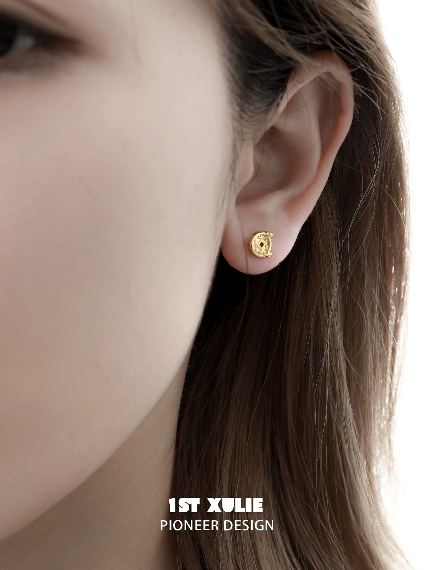 Gold lucky coin cat stud earrings displayed on a model's ear for a stylish look