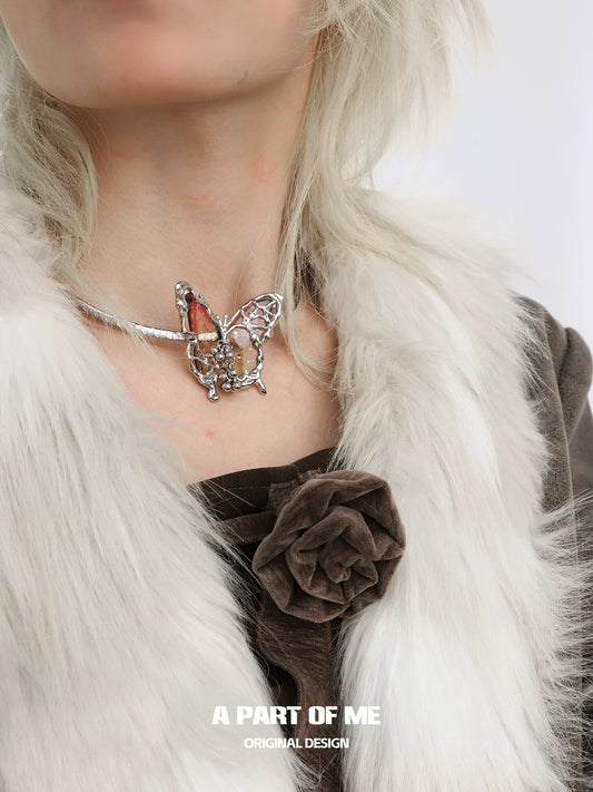 A PART OF ME mechanical butterfly necklace with intricate detailing and silver accents worn on a model