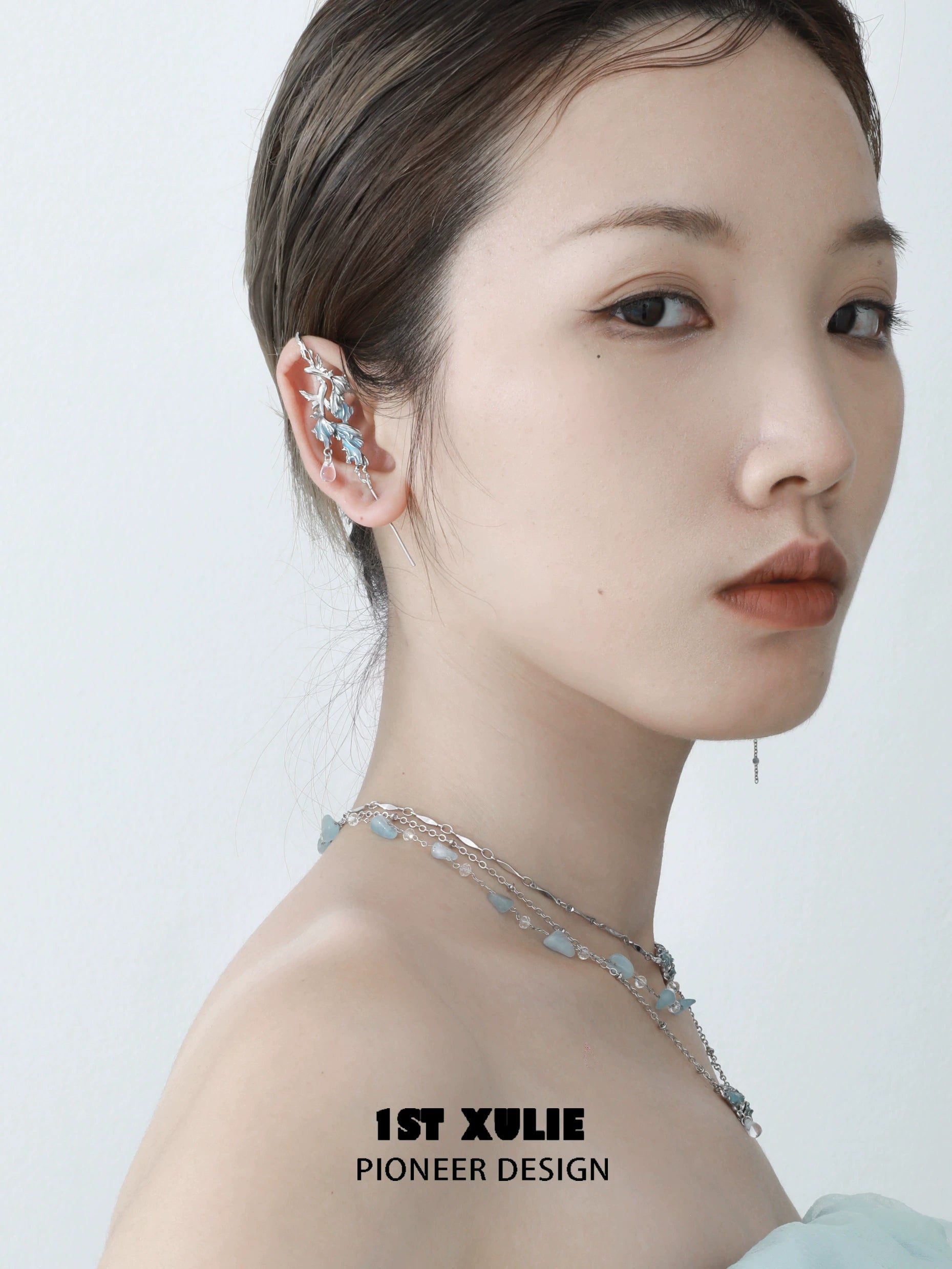 Elegant mermaid tail ear piercing jewelry displayed on a model's ear with a soft, stylish look