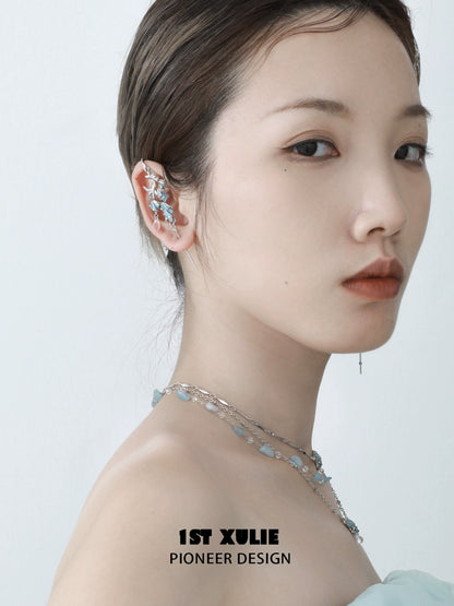 Elegant mermaid tail ear piercing jewelry displayed on a model's ear with a soft, stylish look