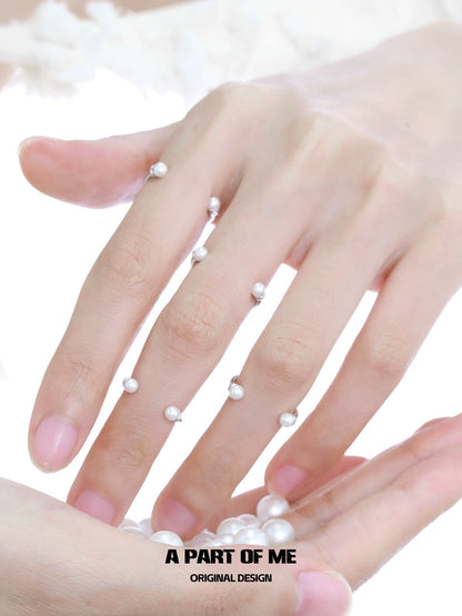 Minimal pearl ring displayed on elegant hands, showcasing delicate design with luminous pearls