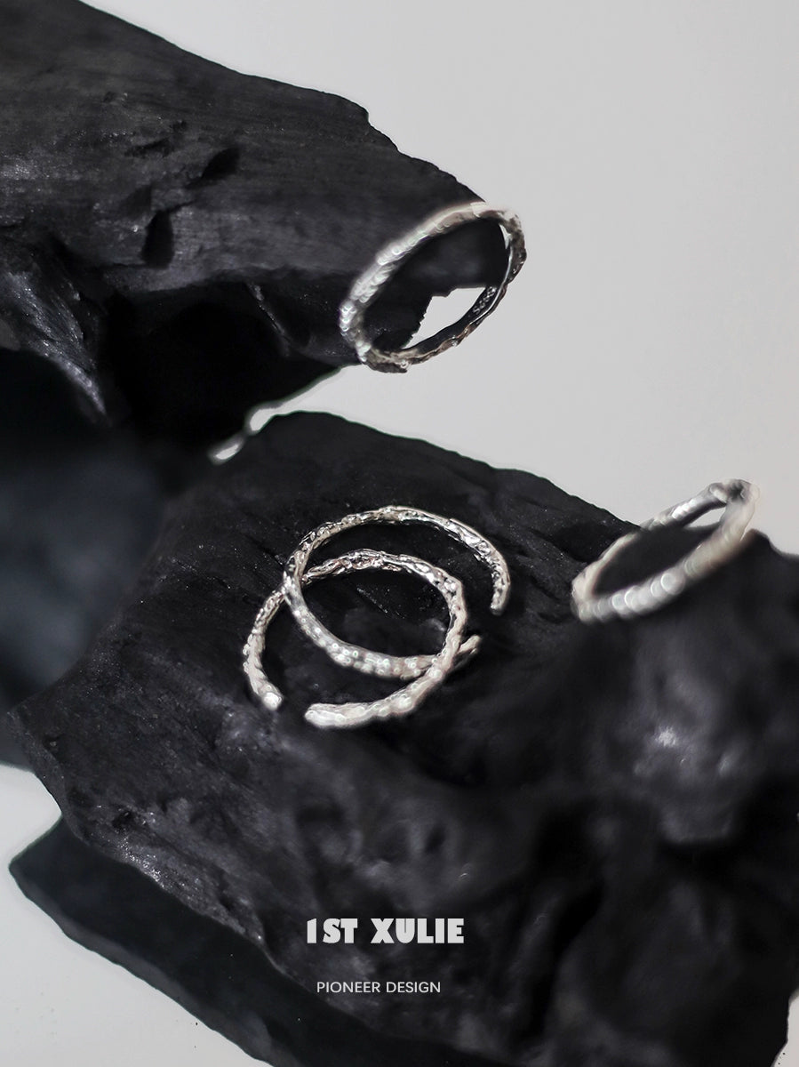 Minimalist silver ring set displayed on textured black surface for modern jewelry lovers