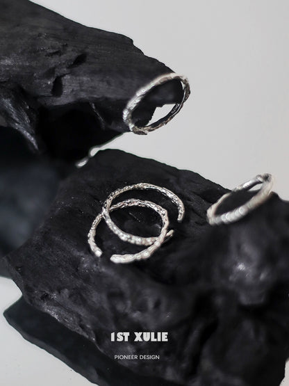Minimalist silver ring set displayed on textured black surface for modern jewelry lovers