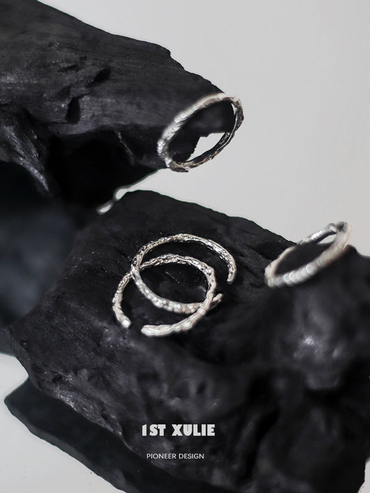 Minimalist silver ring set displayed on textured black surface for modern jewelry lovers
