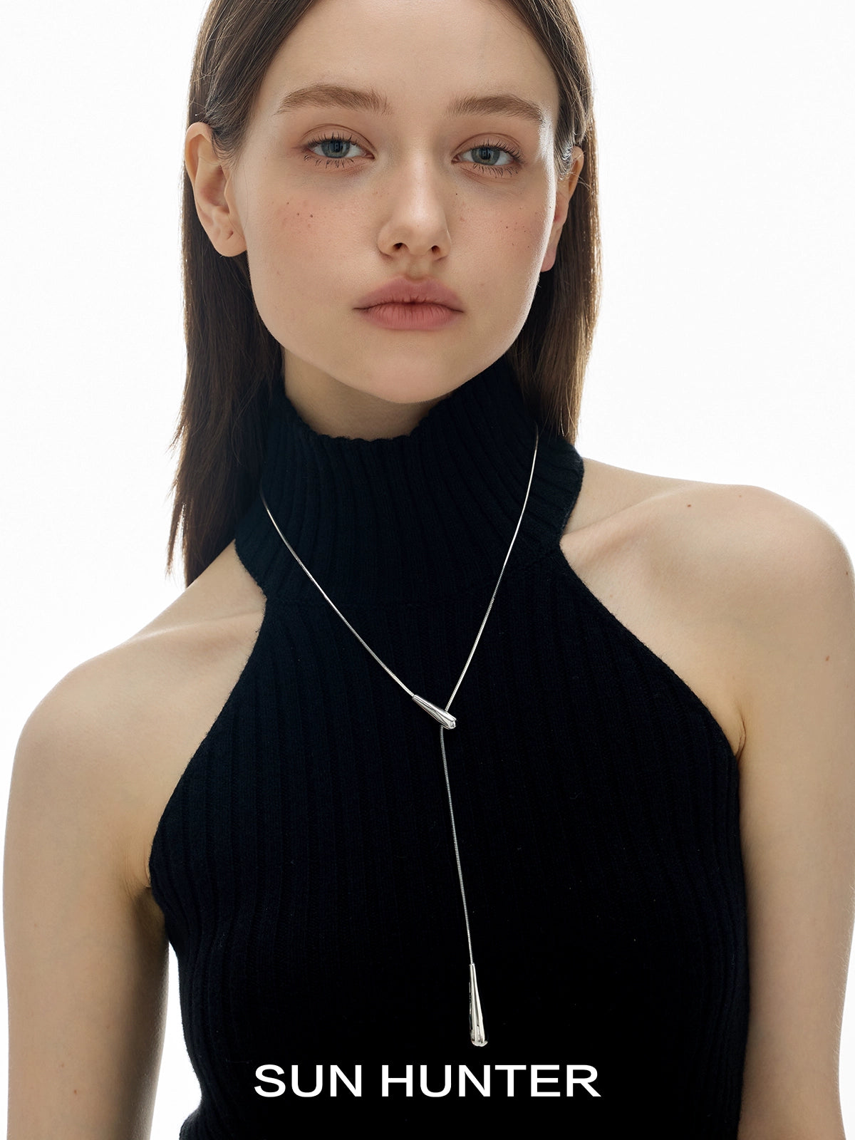 SUN HUNTER molten drop necklace elegantly worn by model with a stylish black top