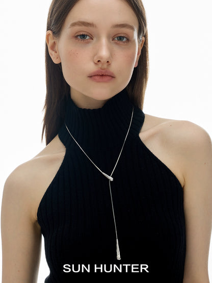 SUN HUNTER molten drop necklace elegantly worn by model with a stylish black top
