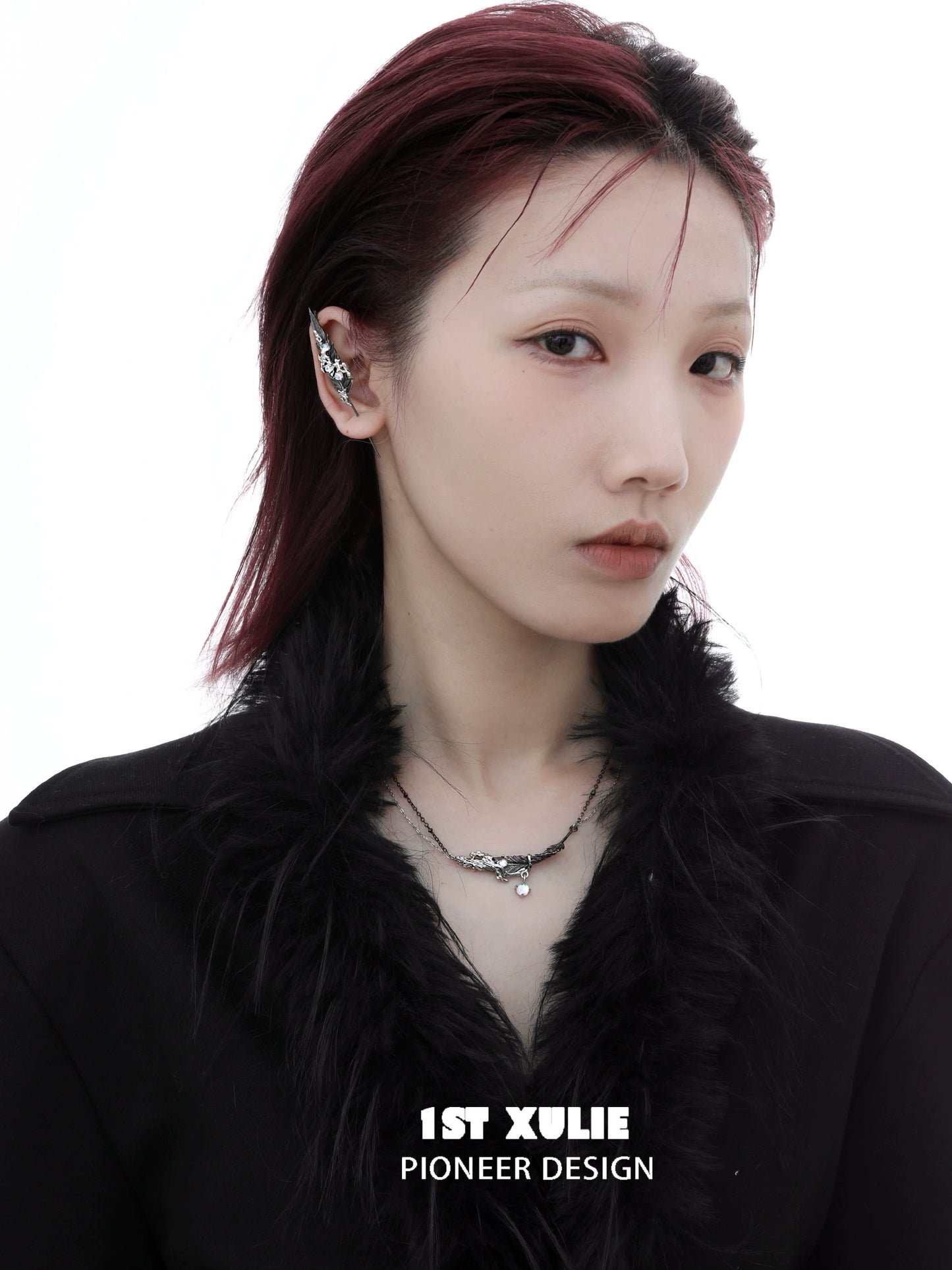 Model showcasing a mystic feather piercing earring in a stylish black outfit with a chic hairstyle