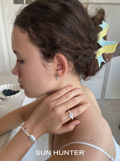 SUN HUNTER ocean memory pearl bracelet worn by a girl with a hairstyle and accessories
