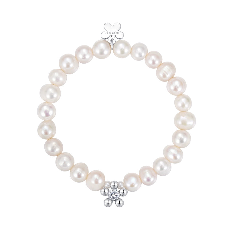 Elegant SUN HUNTER pearl bracelet for women featuring a silver flower charm and lustrous pearls