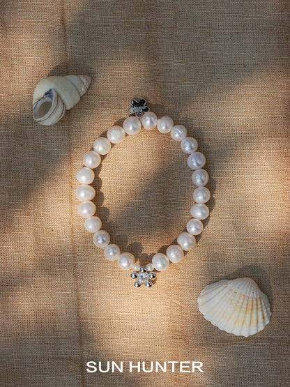 Elegant pearl bracelet for women by SUN HUNTER with a floral clasp and seashell accents