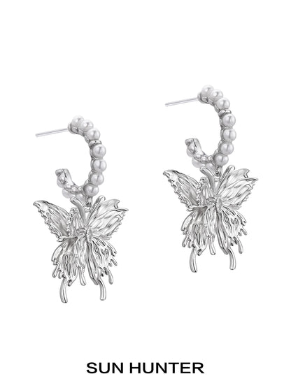 Elegant pearl butterfly earrings by SUN HUNTER featuring intricate metal design with pearl accents